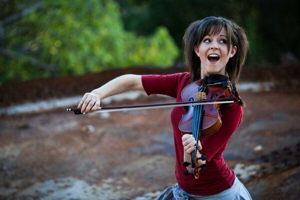 Lindsey Stirling, jouant du violon sur fond de nature