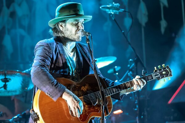 Musicien dans un chapeau avec une guitare chante lors d un concert