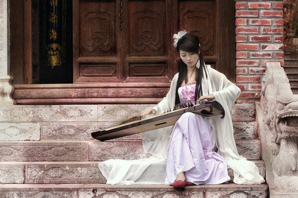 Asian girl plays on guzheng