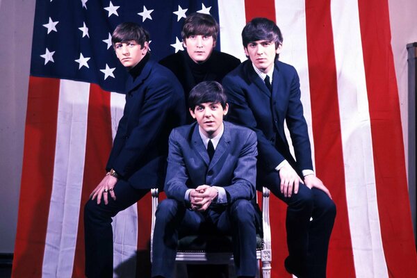 The beatles na tle amerykańskiej flagi McCartney siedzi z przodu