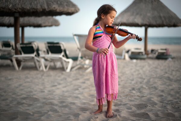 Bambina in abito rosa che suona il violino