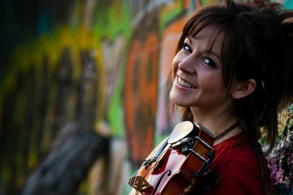 Fille souriante sur fond de graffiti avec violon