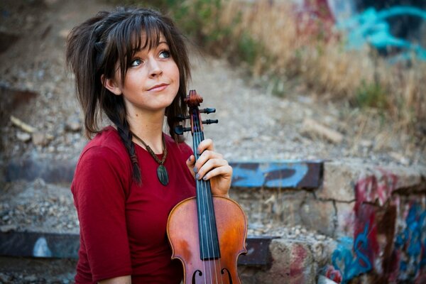 Lindsey Stirling draußen mit einer Geige