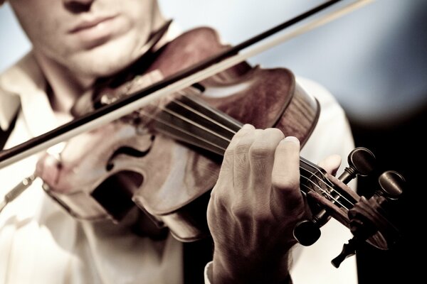 Ein Mann spielt Geige auf einem dunklen Hintergrund
