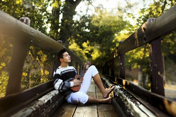 Joven con guitarra en el puente