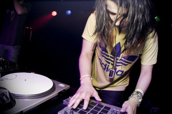 Ein DJ spielt Dubstep-Musik in einem stilvollen T-Shirt bei der Arbeit