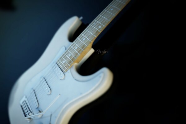 White guitar on a black background