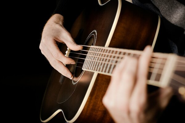 Hands on acoustic guitar strings