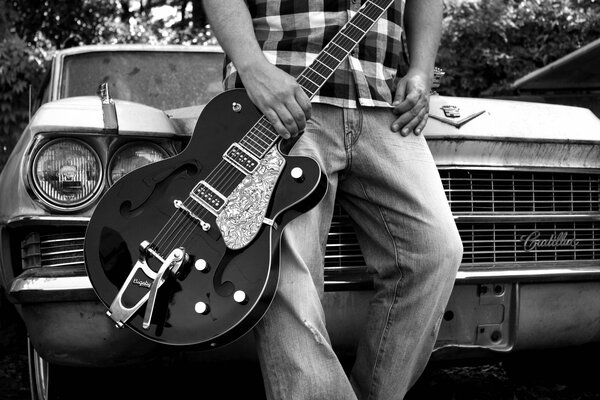 Coche retro. El chico con la guitarra en el fondo del coche