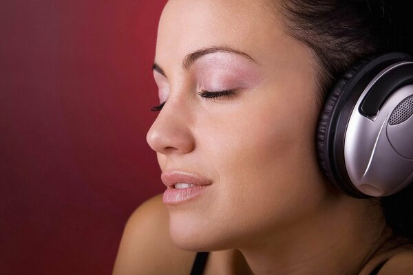 Jeune fille écoute de la musique dans un casque avec les yeux fermés