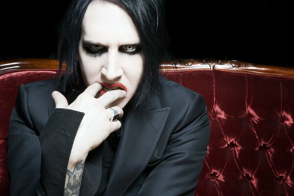 Marilyn Manson sur un canapé en velours rouge