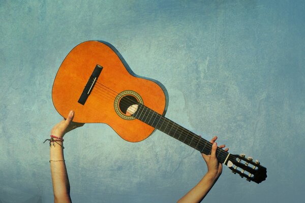 The guitar is held on a blue background