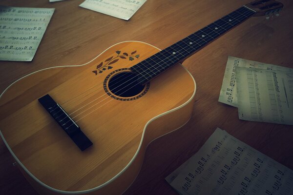 Guitarra en la mesa entre las notas