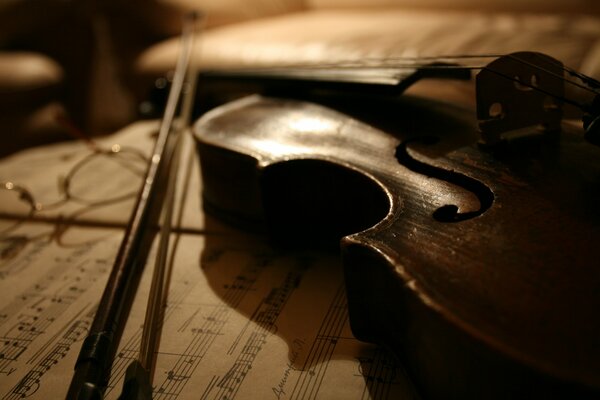 A violin lying on a notebook with notes