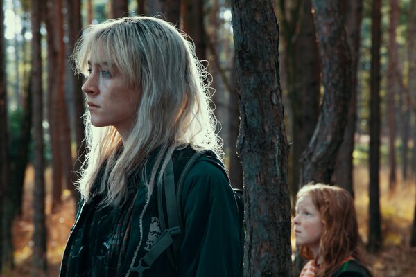 Blonde girl and red-haired girl in the forest frame from the movie