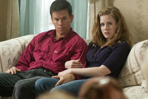 Mark Wahlberg and Amy Adams are sitting on the couch