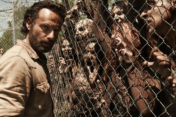 Rick Grimes de the Walking Dead al lado de la valla con los muertos