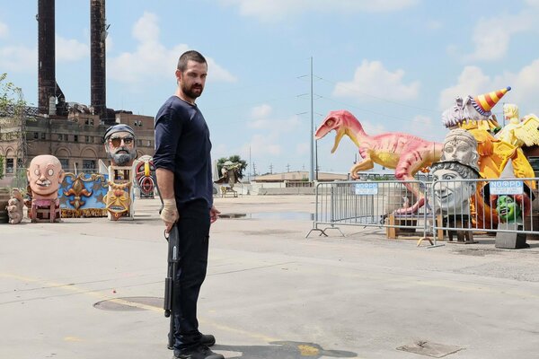 Anthony Starr con un arma en una atracción para niños