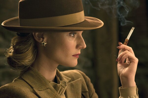 Diana Kruger con un sombrero y un cigarrillo