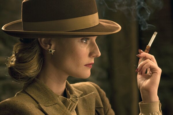 Diane Kruger dans un chapeau et une cigarette