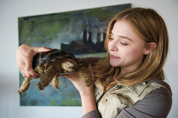 Chica sosteniendo una gran tortuga