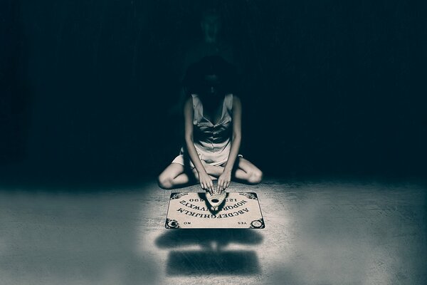 Ouija board girl on dark background