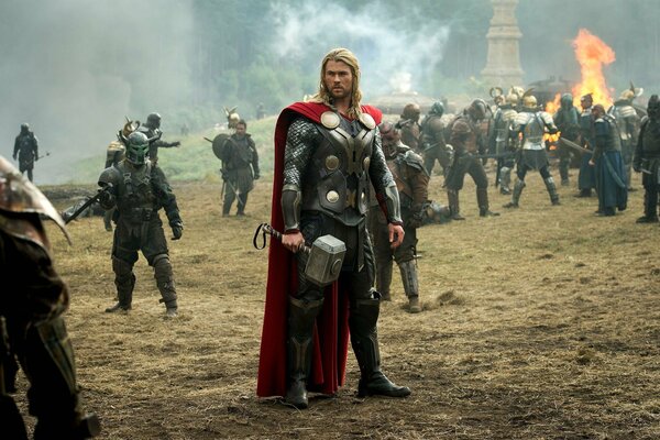 Thor with a hammer stands on the battlefield