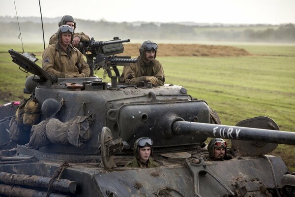 Fünf Soldaten fahren mit einem Panzer