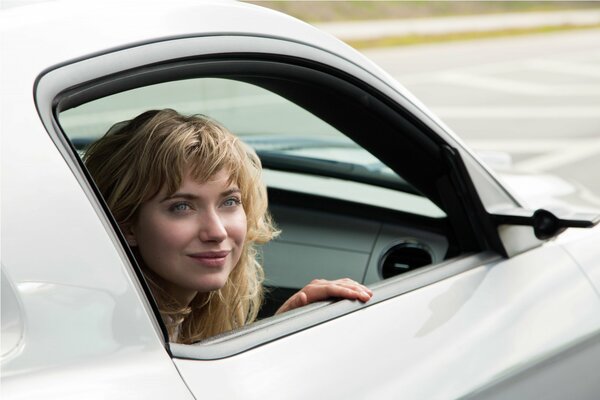 Sourire délicat de la jeune fille dans la fenêtre de la voiture