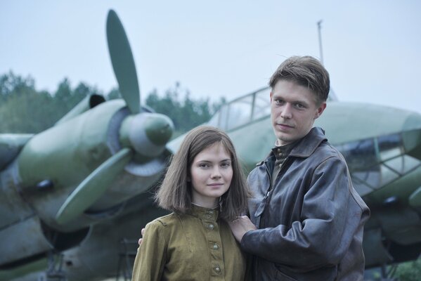 A couple of lovers are standing by Soviet planes