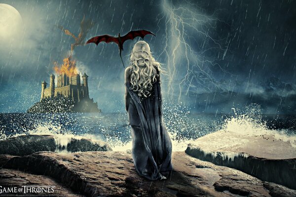 The mother of dragons stands on a rock in the pore and looks at the burning castle
