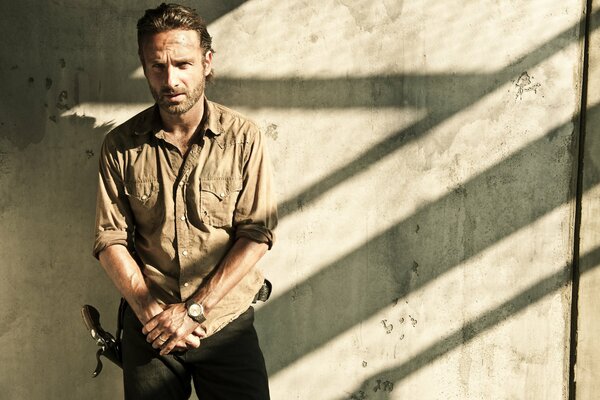 Rick Grimes on the background of a concrete wall The Walking Dead