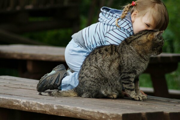 Chica jugando con un gato gris