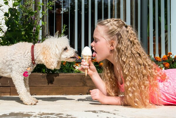 Fille avec un chien manger de la crème glacée