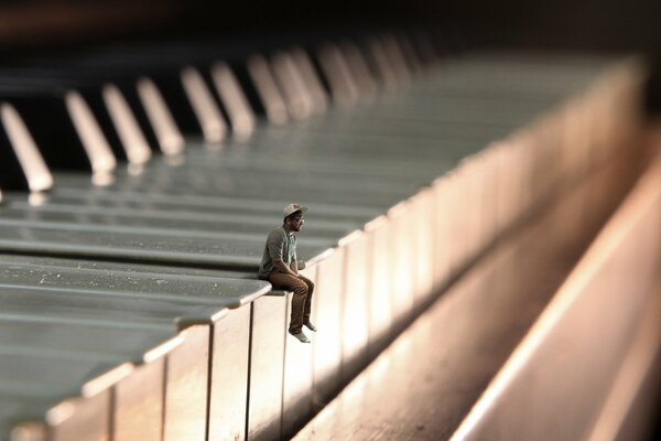 A little man is sitting on the piano