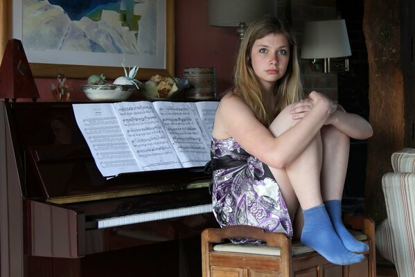 Jeune fille assise à côté du piano