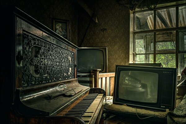Ein dunkler Raum in einem verlassenen Haus, mit einem staubigen Klavier und alten Fernsehgeräten