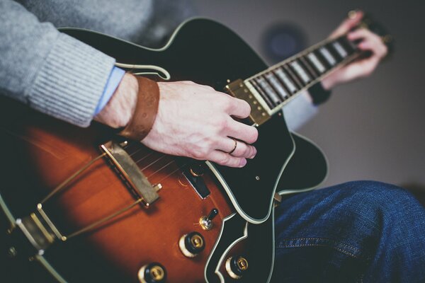 A man plays a musical instrument - the guitar