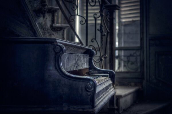 Piano antiguo con teclas abiertas en el polvo