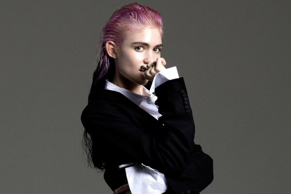 La chanteuse canadienne Grimes, en costume masculin