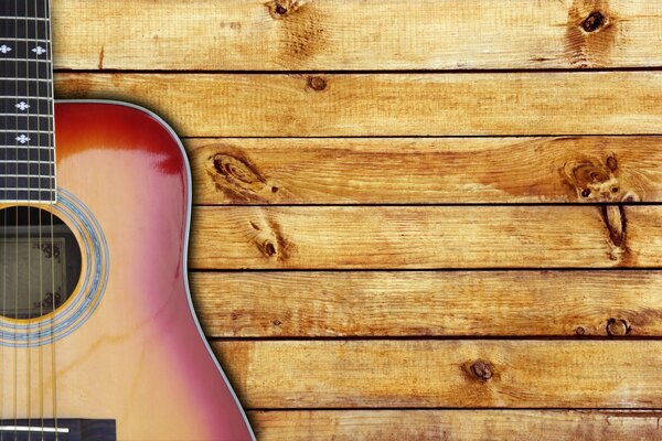 Guitar on the background of wooden boards