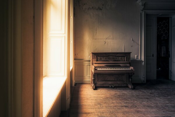 Una habitación vacía con un piano antiguo
