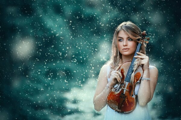 Девушка со скрипкой на фоне снега