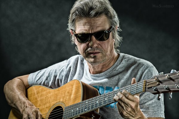 Jerry Wall con gafas negras con guitarra