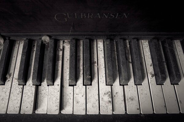 The keys of an old Gulbransen piano in the dust