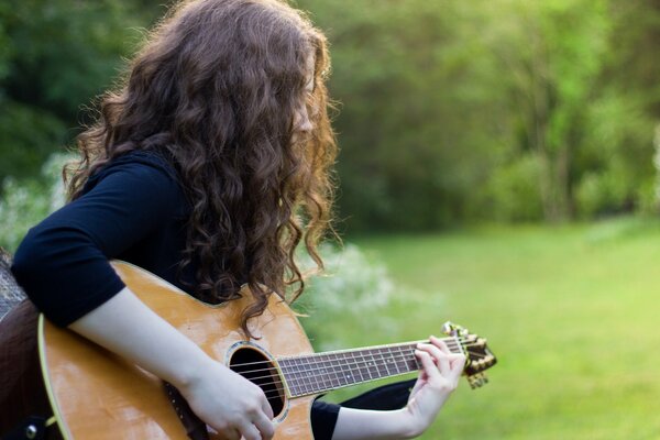 A girl on the field with a guitar in her hands