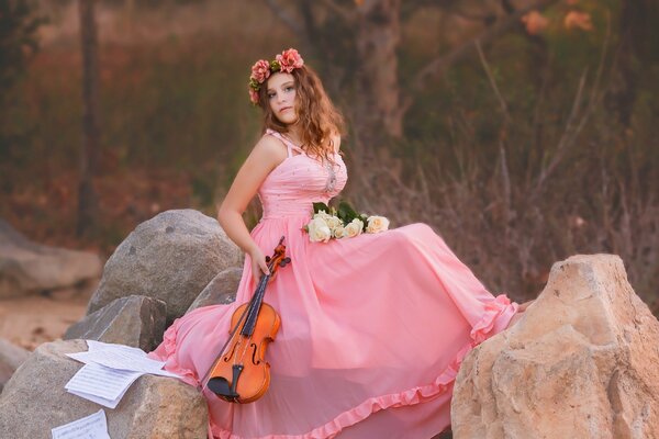 Glamorous violinist in a pink dress