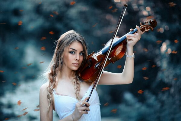 Ragazza con violino nel bosco a giocare