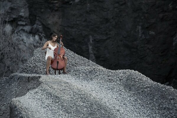 Mädchen spielen auf einem Cello in den Bergen