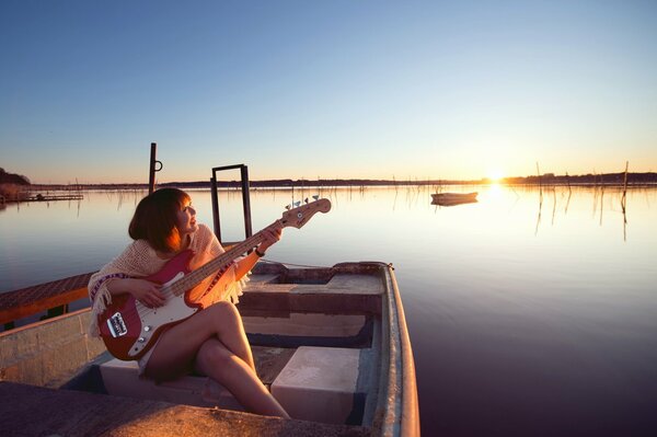 A girl with a guitar in a boat